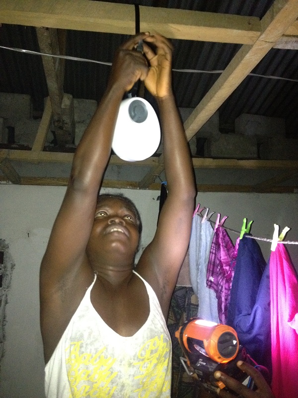 Miatta attaches GravityLight to a beam in her home.