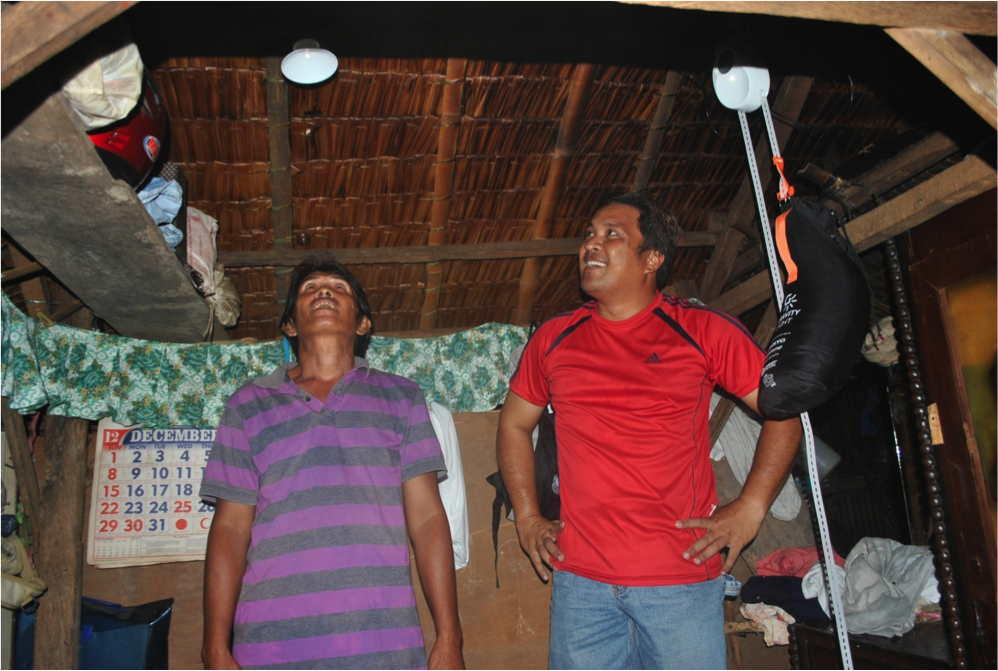 Mr. Primitivo Saldua and Mr Adrian Ampong survey their newly installed GravityLight and SatLights. 