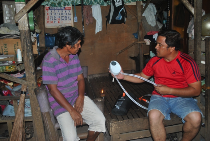 Mr Adrian Ampong talks Mr. Primitivo Saldua through how to set up his GravityLight.